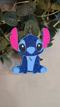 Blue glitter Stitch-inspired handmade car freshie with pink ears hanging from a rearview mirror.